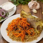 Qabuli palow with tender lamb shank, carrots, and raisins. Famous afghan cuisine. In our menu at bamyan palace